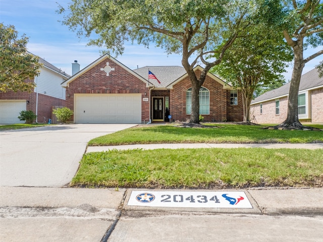 20434 Willow Trace Dr, Cypress, TX 77433 - view of front of home featuring brick siding, a garage, a front yard, and driveway
