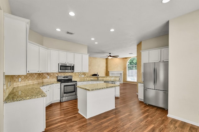 20434 Willow Trace Dr, Cypress, TX 77433 - kitchen with appliances with stainless steel finishes, ceiling fan, decorative backsplash, dark wood-style floors, and a center island