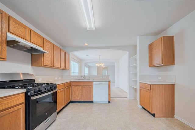 427 Sunset Colony Dr, Rosharon, TX 77583 - kitchen with white dishwasher, range with gas stovetop, under cabinet range hood, a sink, and arched walkways