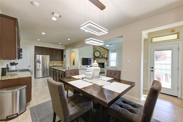 223 Summer Gate Ct, Rosenberg, TX 77469 - dining space with light tile patterned floors, a fireplace, a ceiling fan, and recessed lighting