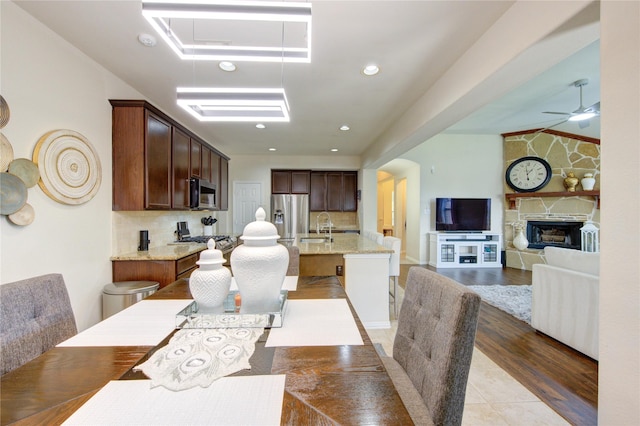 223 Summer Gate Ct, Rosenberg, TX 77469 - dining area with ceiling fan, a fireplace, recessed lighting, and light wood finished floors