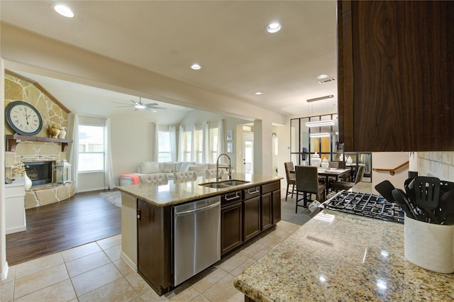 223 Summer Gate Ct, Rosenberg, TX 77469 - kitchen with dishwasher, a sink, dark brown cabinetry, a stone fireplace, and open floor plan