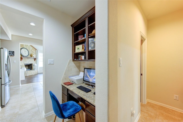 223 Summer Gate Ct, Rosenberg, TX 77469 - office area with light tile patterned floors, baseboards, recessed lighting, a fireplace, and built in desk