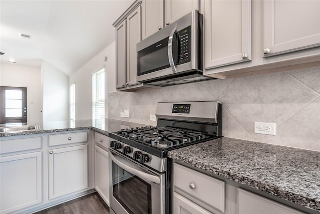 10106 Granite Grove Ln, Richmond, TX 77406 - kitchen featuring appliances with stainless steel finishes, dark stone countertops, decorative backsplash, and lofted ceiling