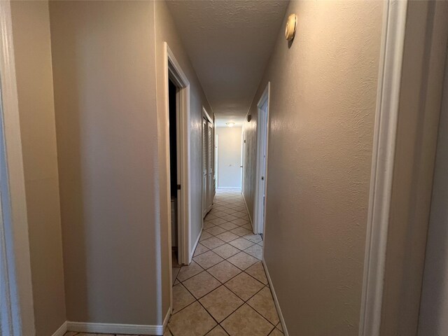 958 Grand Junction Dr, Katy, TX 77450 - hall featuring light tile patterned floors, baseboards, and a textured ceiling