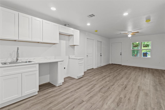 805 19th Ave N, Texas City, TX 77590 - kitchen featuring a sink, light wood-style floors, white cabinetry, a ceiling fan, and baseboards
