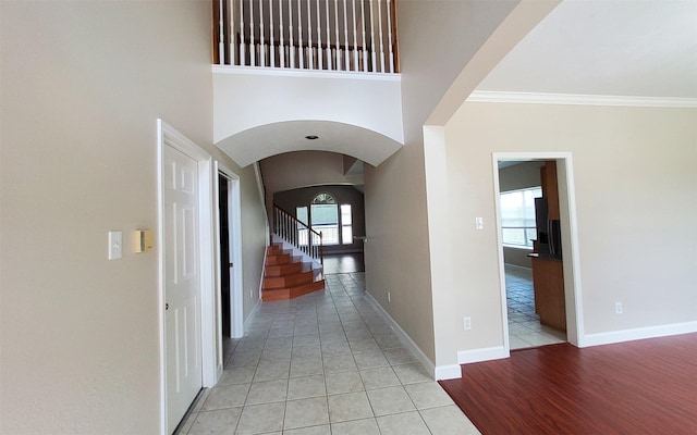 2707 Sun Beam Ct, Pearland, TX 77584 - hallway with arched walkways, light tile patterned floors, baseboards, and stairway