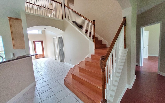 2707 Sun Beam Ct, Pearland, TX 77584 - stairway with arched walkways, a high ceiling, baseboards, and tile patterned floors
