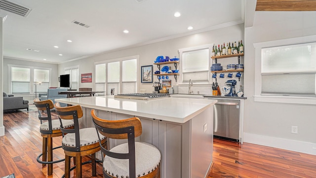 405 N Grace St N, Houston, TX 77003 - kitchen featuring appliances with stainless steel finishes, a sink, crown molding, a kitchen island, and dark wood-style floors