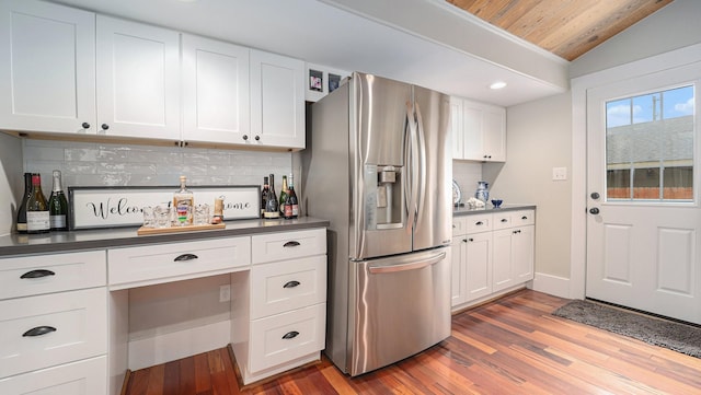 405 N Grace St N, Houston, TX 77003 - kitchen featuring stainless steel fridge, decorative backsplash, wood finished floors, dark countertops, and lofted ceiling