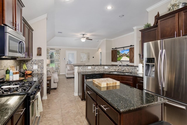 23118 Mestina Knoll Dr, Porter, TX 77365 - kitchen with stainless steel appliances, a sink, decorative backsplash, open floor plan, and ornamental molding