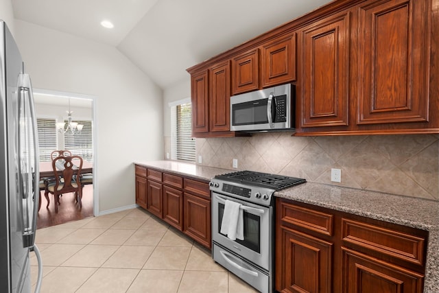 31870 Forest Park Trl, Conroe, TX 77385 - kitchen featuring appliances with stainless steel finishes, vaulted ceiling, backsplash, a chandelier, and light stone counters