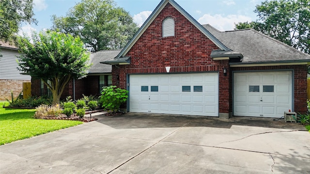 53 S Calla Lily Ct, Lake Jackson, TX 77566 - traditional home featuring a garage, concrete driveway, brick siding, and roof with shingles