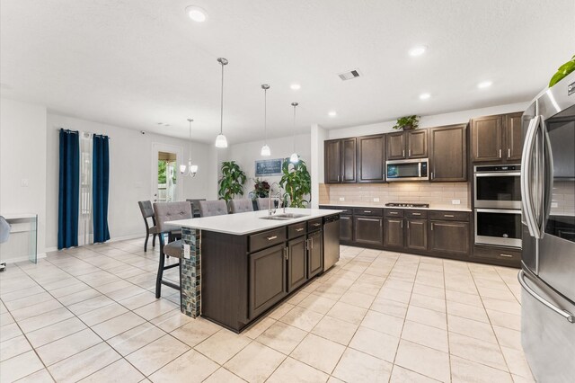 1164 Clonmore Ct, Conroe, TX 77304 - kitchen with stainless steel appliances, a sink, light countertops, backsplash, and dark brown cabinets