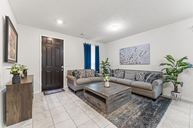 1164 Clonmore Ct, Conroe, TX 77304 - living room featuring light tile patterned floors, baseboards, and a textured ceiling