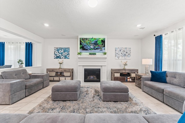 1164 Clonmore Ct, Conroe, TX 77304 - tiled living room featuring a glass covered fireplace, a textured ceiling, and recessed lighting