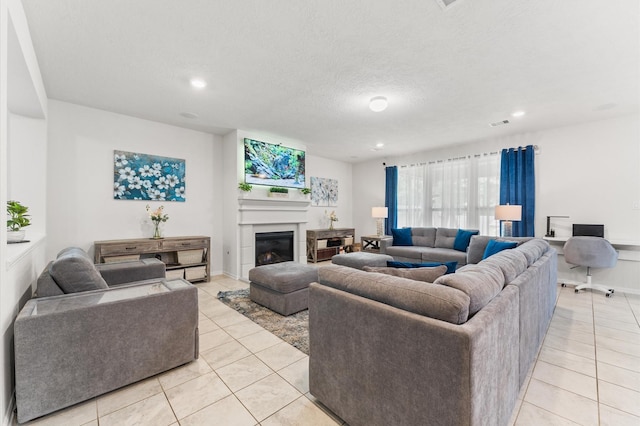 1164 Clonmore Ct, Conroe, TX 77304 - living room with light tile patterned floors, a glass covered fireplace, recessed lighting, baseboards, and a textured ceiling