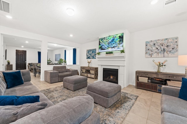 1164 Clonmore Ct, Conroe, TX 77304 - living area with light tile patterned floors, recessed lighting, a warm lit fireplace, and baseboards
