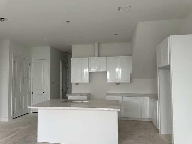 1934 Wildpacher Ln, Houston, TX 77080 - kitchen featuring a center island, white cabinets, and concrete flooring