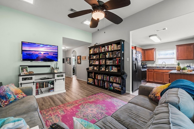 12218 Estelle Ln, Pinehurst, TX 77362 - living room featuring light wood-type flooring, ceiling fan, and baseboards