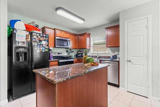 12218 Estelle Ln, Pinehurst, TX 77362 - kitchen with stainless steel appliances, light tile patterned floors, dark stone counters, a center island, and baseboards