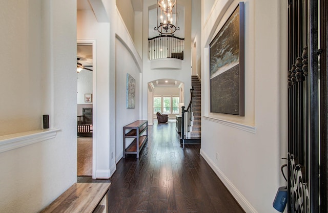 31297 New Forest Park Ln, Spring, TX 77386 - entryway with arched walkways, dark wood-type flooring, a chandelier, stairs, and a ceiling fan