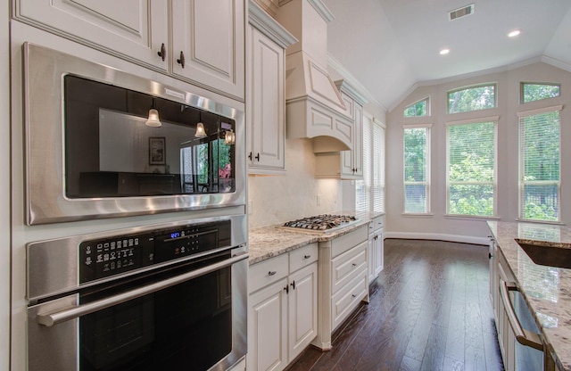 31297 New Forest Park Ln, Spring, TX 77386 - kitchen featuring appliances with stainless steel finishes, dark wood-type flooring, white cabinetry, lofted ceiling, and light stone countertops