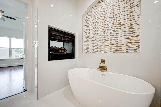825 W 16th St Unit A, Houston, TX 77008 - bathroom featuring tile walls, a freestanding bath, a ceiling fan, and a multi sided fireplace