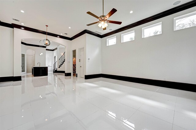 825 W 16th St Unit A, Houston, TX 77008 - unfurnished room with crown molding, arched walkways, light tile patterned floors, ceiling fan, and baseboards