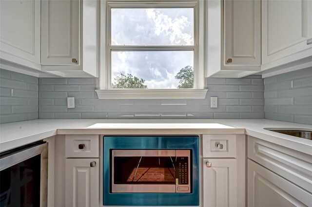 825 W 16th St Unit A, Houston, TX 77008 - kitchen with wine cooler, stainless steel microwave, white cabinetry, and light countertops