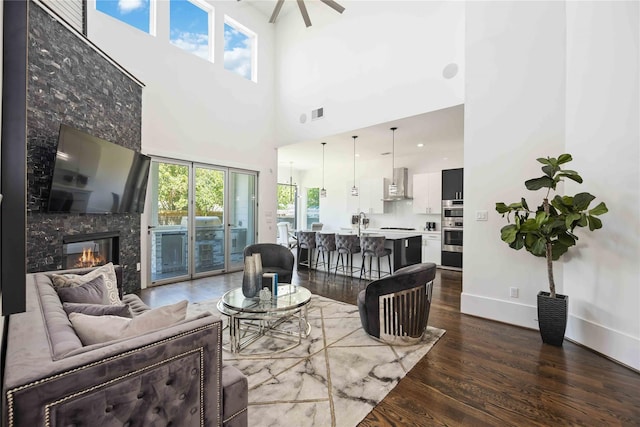 2310 Althea Dr, Houston, TX 77018 - living area featuring dark wood-style floors, a high ceiling, baseboards, a fireplace, and a ceiling fan