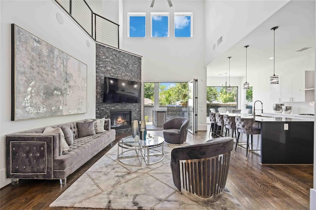 2310 Althea Dr, Houston, TX 77018 - living room featuring dark wood-style floors, a glass covered fireplace, a high ceiling, and a ceiling fan