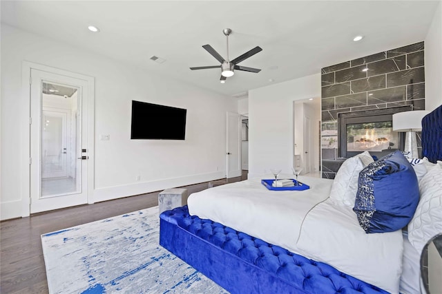 2310 Althea Dr, Houston, TX 77018 - bedroom featuring a tiled fireplace, wood finished floors, recessed lighting, ceiling fan, and baseboards