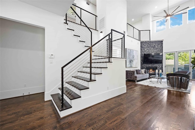 2310 Althea Dr, Houston, TX 77018 - stairs featuring a high ceiling, a warm lit fireplace, baseboards, ceiling fan, and wood finished floors