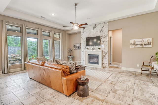 1010 Zoyas Creek Trl, Katy, TX 77494 - living area with light marble finish flooring, a raised ceiling, a fireplace, baseboards, and a ceiling fan