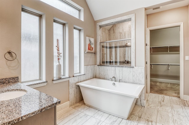 1010 Zoyas Creek Trl, Katy, TX 77494 - bathroom featuring a stall shower, marble look tile flooring, a spacious closet, a soaking tub, and lofted ceiling