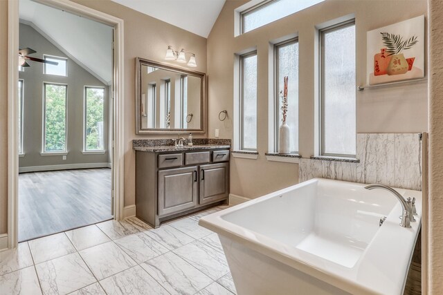 1010 Zoyas Creek Trl, Katy, TX 77494 - bathroom with vaulted ceiling, a soaking tub, ceiling fan, marble finish flooring, and vanity