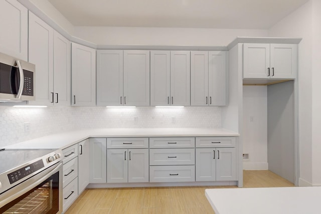 117 Keaau Ct, Bastrop, TX 78602 - kitchen with appliances with stainless steel finishes, tasteful backsplash, light countertops, and light wood finished floors