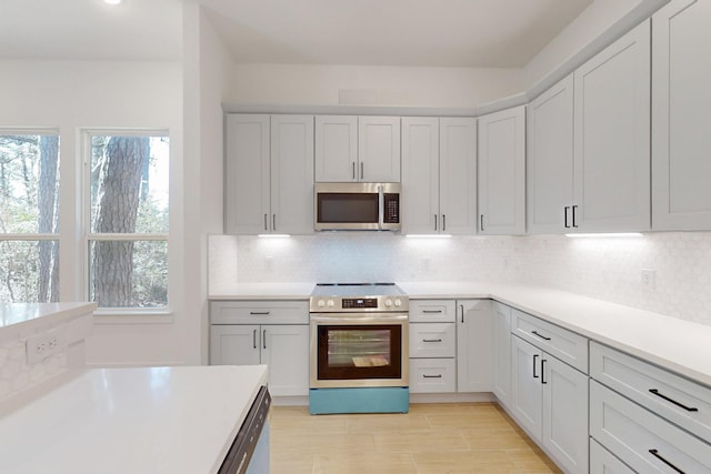 117 Keaau Ct, Bastrop, TX 78602 - kitchen with appliances with stainless steel finishes, decorative backsplash, light countertops, and white cabinets