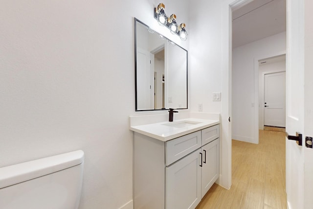 117 Keaau Ct, Bastrop, TX 78602 - half bathroom with wood finished floors, vanity, toilet, and baseboards