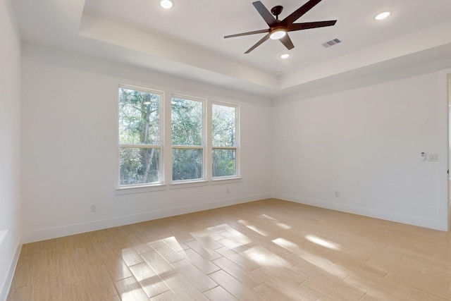 117 Keaau Ct, Bastrop, TX 78602 - unfurnished room featuring a tray ceiling, ceiling fan, light wood finished floors, recessed lighting, and baseboards