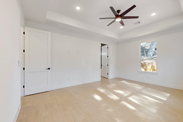 117 Keaau Ct, Bastrop, TX 78602 - empty room with a tray ceiling, ceiling fan, recessed lighting, baseboards, and light wood-type flooring