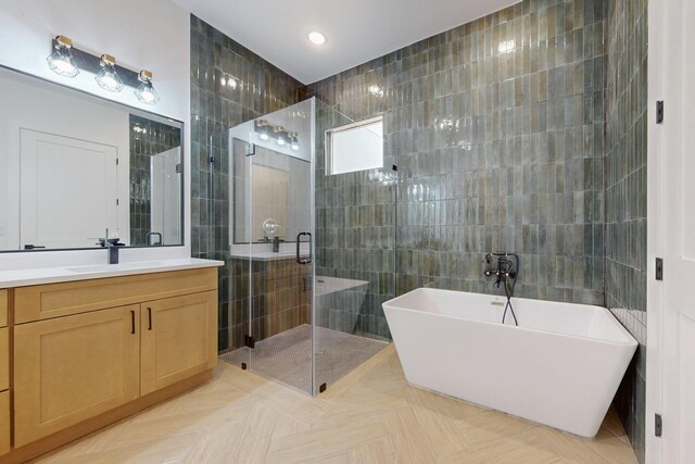 117 Keaau Ct, Bastrop, TX 78602 - bathroom featuring tile walls, a soaking tub, a stall shower, vanity, and recessed lighting