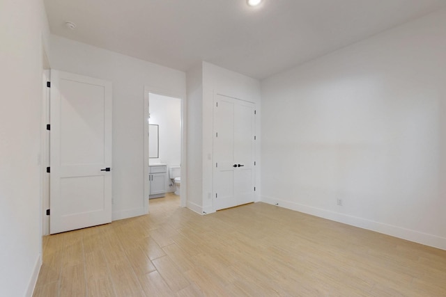 117 Keaau Ct, Bastrop, TX 78602 - unfurnished bedroom featuring baseboards, light wood finished floors, ensuite bathroom, and recessed lighting