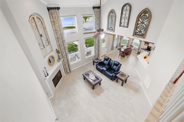9034 Cedar Run Fls, Tomball, TX 77375 - tiled living area featuring a high ceiling, ceiling fan, ornamental molding, and a fireplace with flush hearth