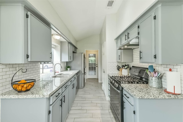 9819 Orangevale Dr, Spring, TX 77379 - kitchen featuring appliances with stainless steel finishes, under cabinet range hood, a sink, vaulted ceiling, and decorative backsplash