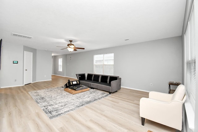 8907 Wildbird Ln, Humble, TX 77338 - living room featuring light wood-style floors, a ceiling fan, and baseboards