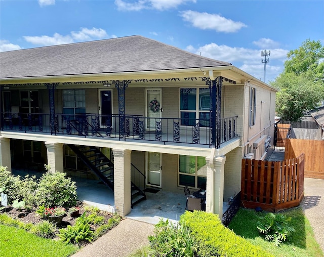 11550 Chimney Rock Rd Unit 329, Houston, TX 77035 - rear view of house with brick siding, stairs, roof with shingles, covered porch, and a patio