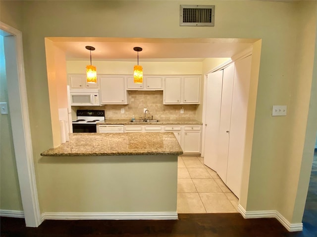 11550 Chimney Rock Rd Unit 329, Houston, TX 77035 - kitchen with range with electric cooktop, white microwave, a sink, white cabinetry, and light stone countertops