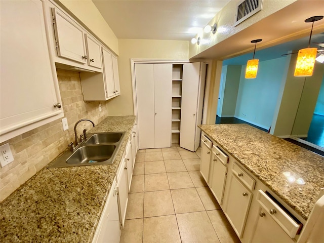 11550 Chimney Rock Rd Unit 329, Houston, TX 77035 - kitchen with a sink, decorative backsplash, light tile patterned floors, hanging light fixtures, and white cabinets